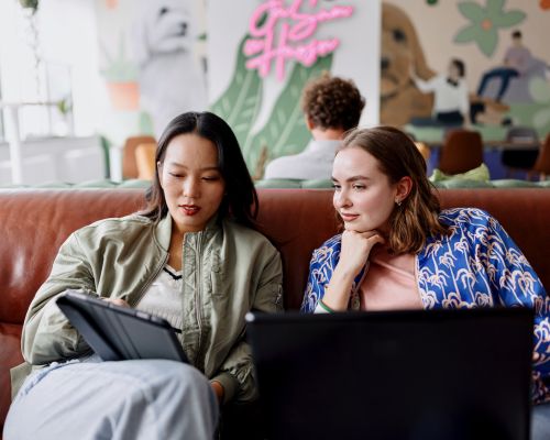 Zwei Frauen nutzen KI in der Personalberatung und schauen gemeinsam auf ein Tablet